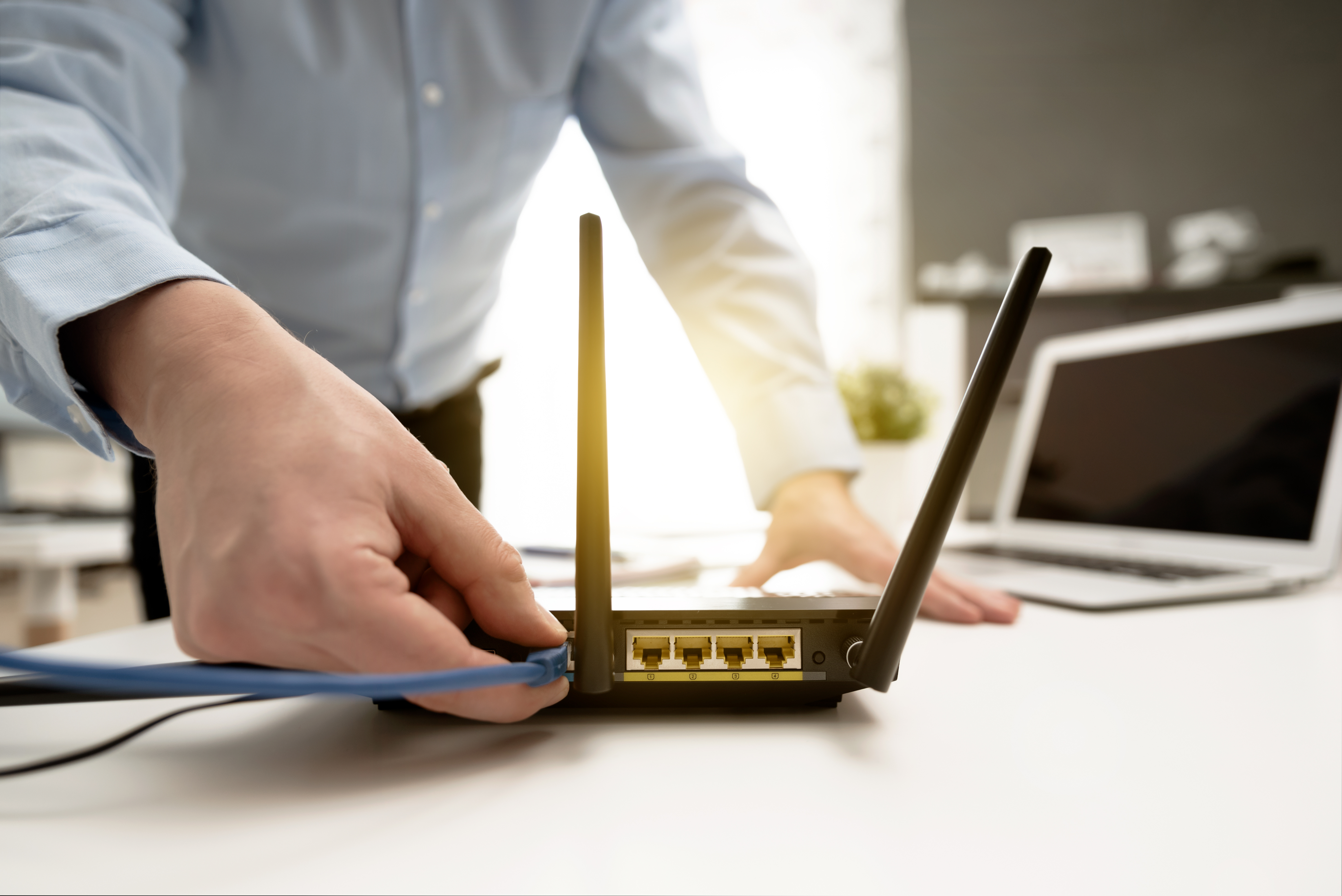 Man connects the cable to the router's socket business broadband